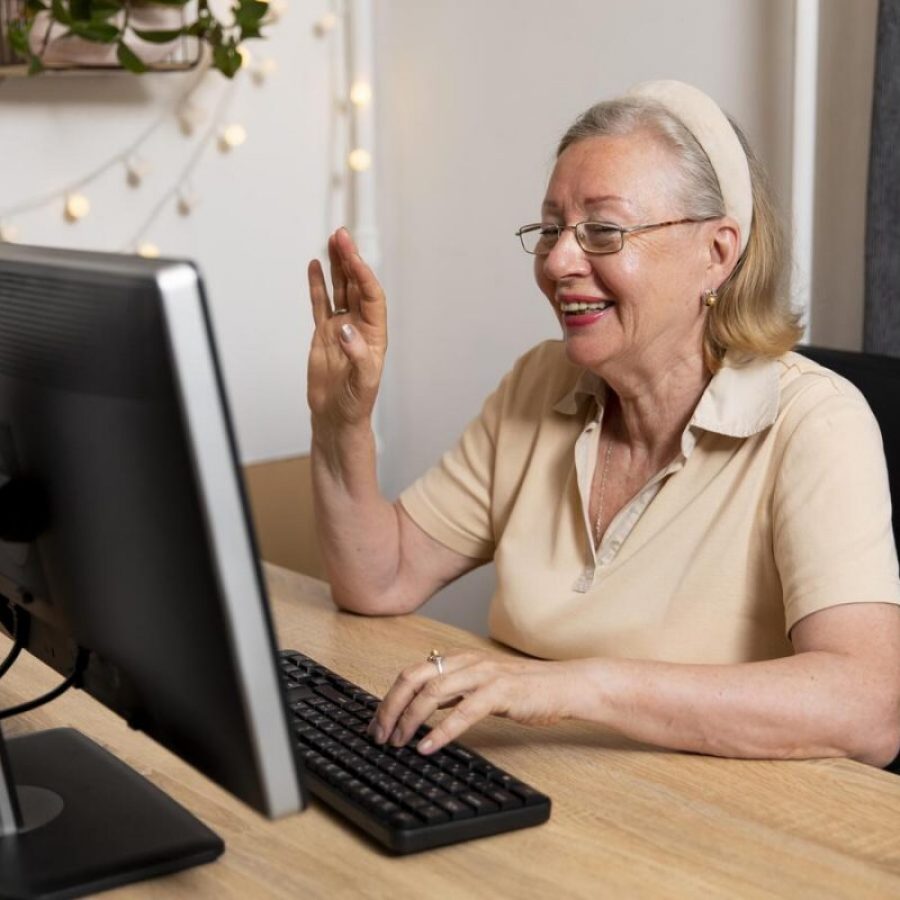 Une personne sénior est entrain de communiquer avec ses petits enfants après ses cours d'informatique