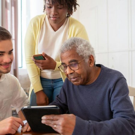 Une petite fille aide son grand-père a utiliser son téléphone