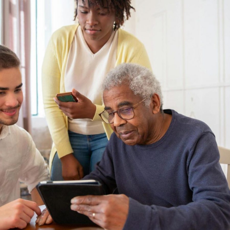 Une petite fille aide son grand-père a utiliser son téléphone