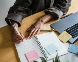 Ordinateur avec cahier et stylo décrivant l'esprit de la conciergerie