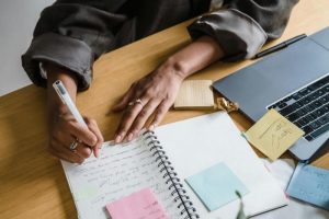 Ordinateur avec cahier et stylo décrivant l'esprit de la conciergerie