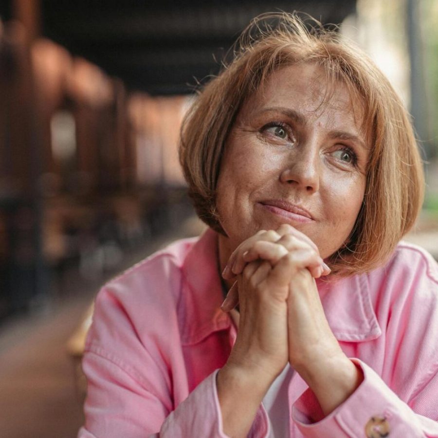 Une personne senior accoudée à la table, qui semble heureuse