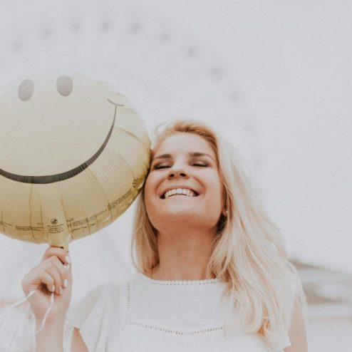 Une jeune femme heureuse avec un ballon smiley
